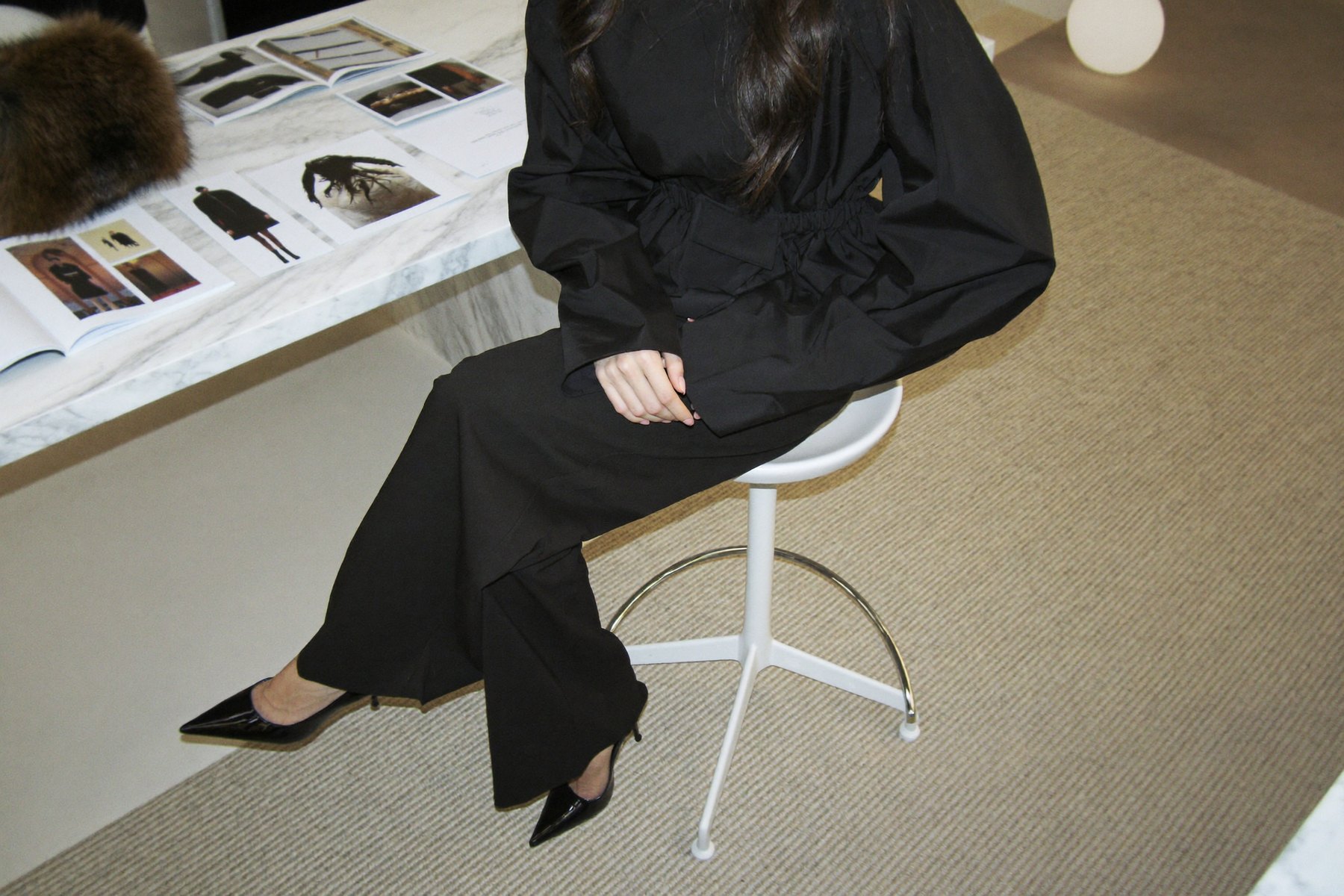 A woman at the atelier table, the reading spread out beside her